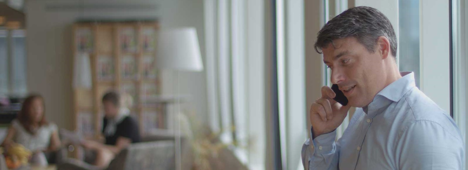 Affärsklädd man pratar i mobiltelefon i kontormiljö