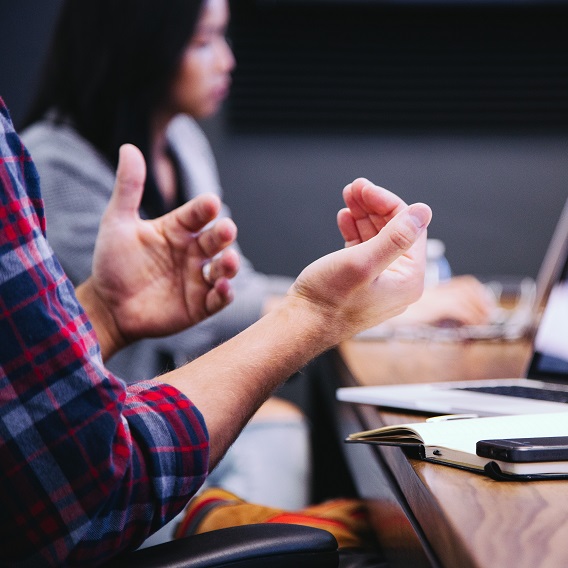 Händer gestikulerar framför dator
