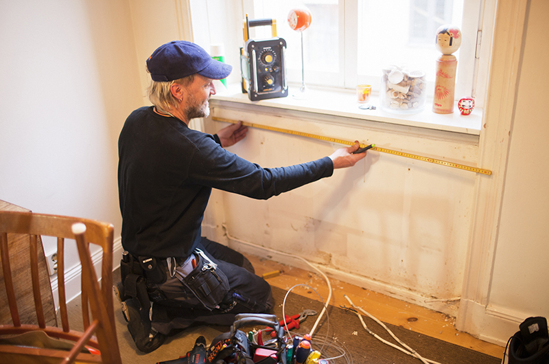Hantverkare mäter vid fönster