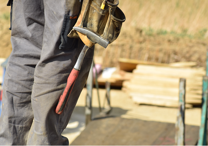 Man i arbetskläder som tittar på bygge