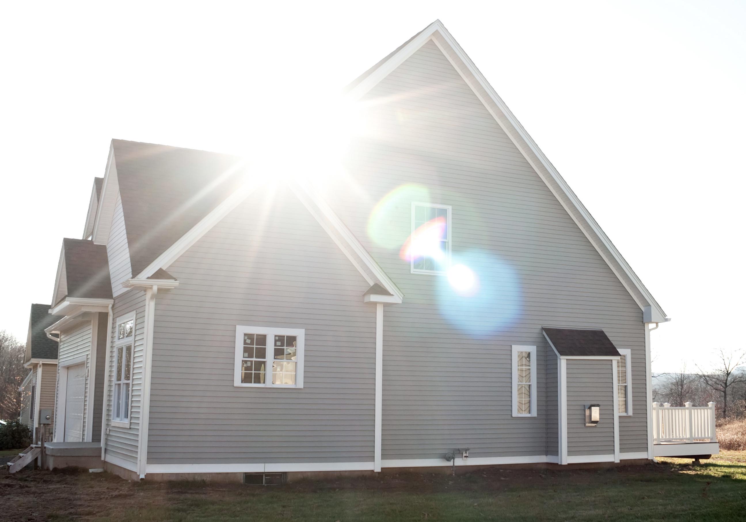 Stort modernt hus med solstrålar på taket