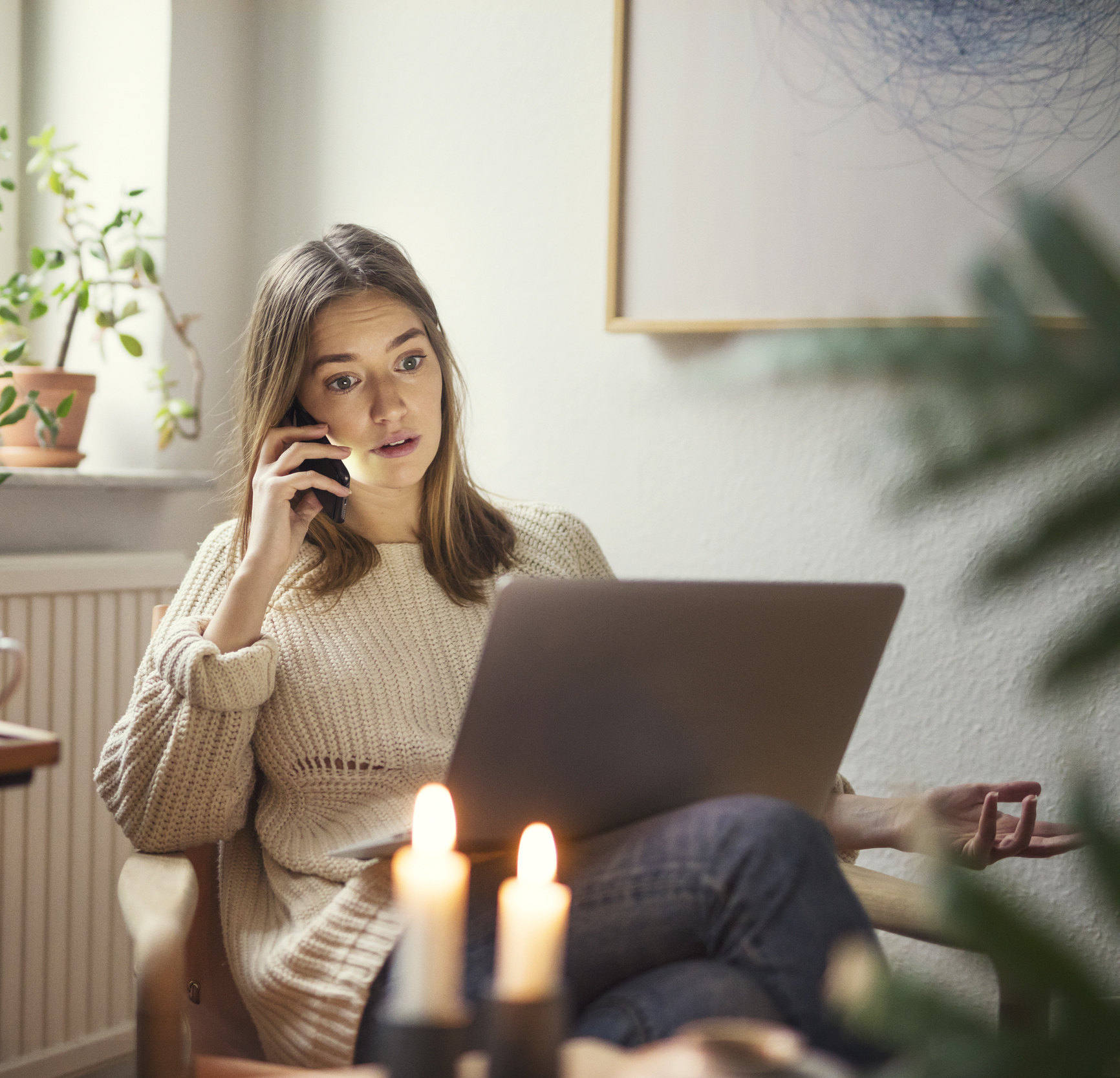 Kvinna pratar i telefon och använder laptop