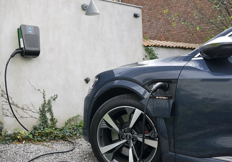 Bil som laddas med laddbox på väggen